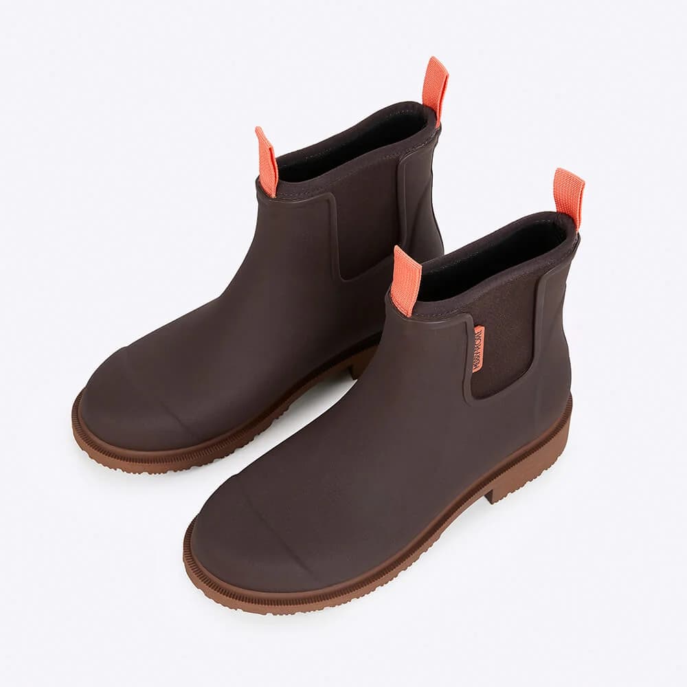 Pair of brown rubber boots with orange accents on a white background