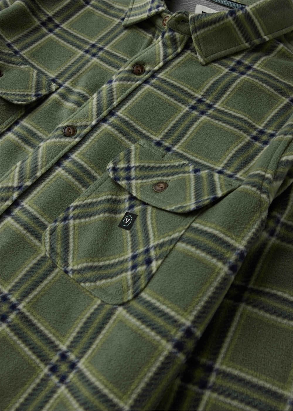 Close-up of a green plaid button-up shirt with a chest pocket and brown buttons, showing the fabric texture and pattern details.