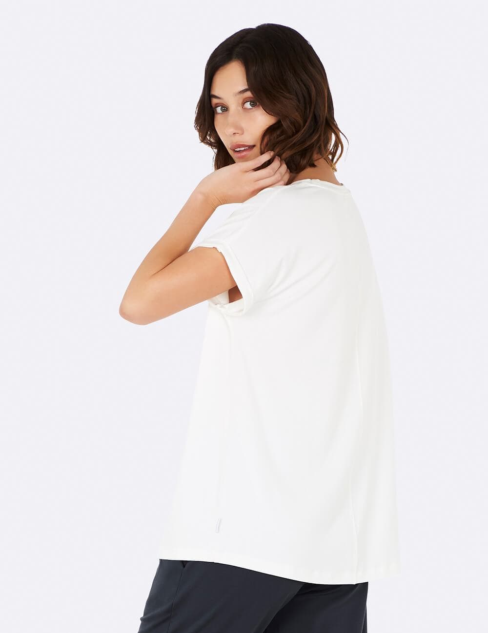 A woman wearing a white short-sleeve crewneck t-shirt, photographed from the back against a clean white studio background.