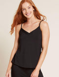 Woman wearing a black tank top against a beige background