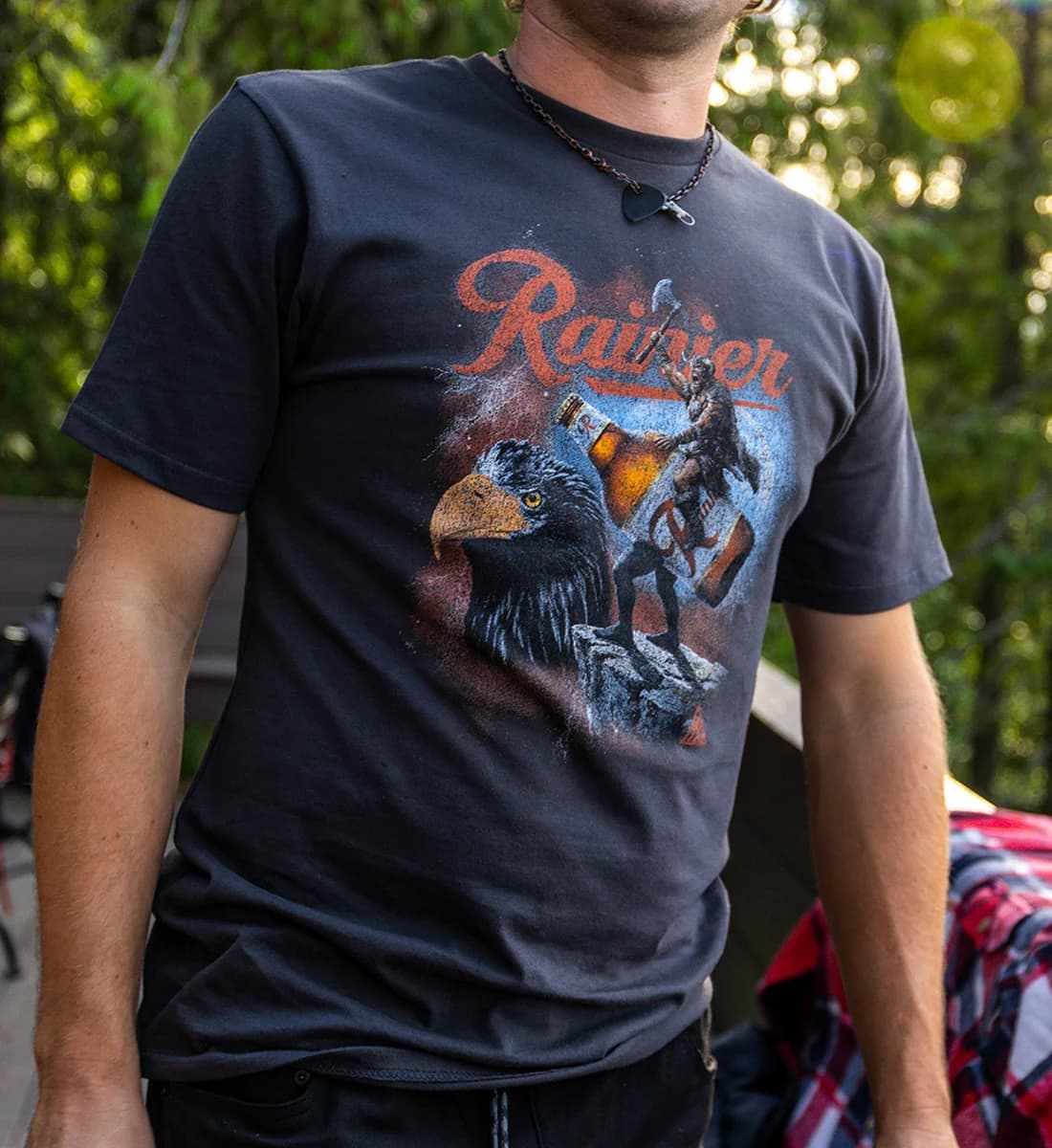 Person wearing a black t-shirt with a graphic design of an eagle and bear, and the word 'Rainier' on it.