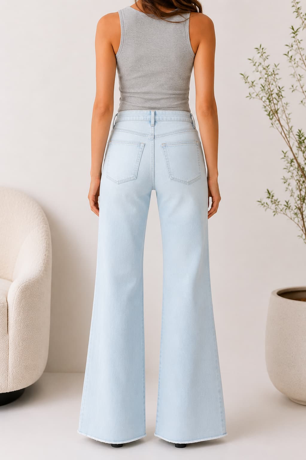 Light blue wide straight leg jeans worn by a woman against a neutral background
