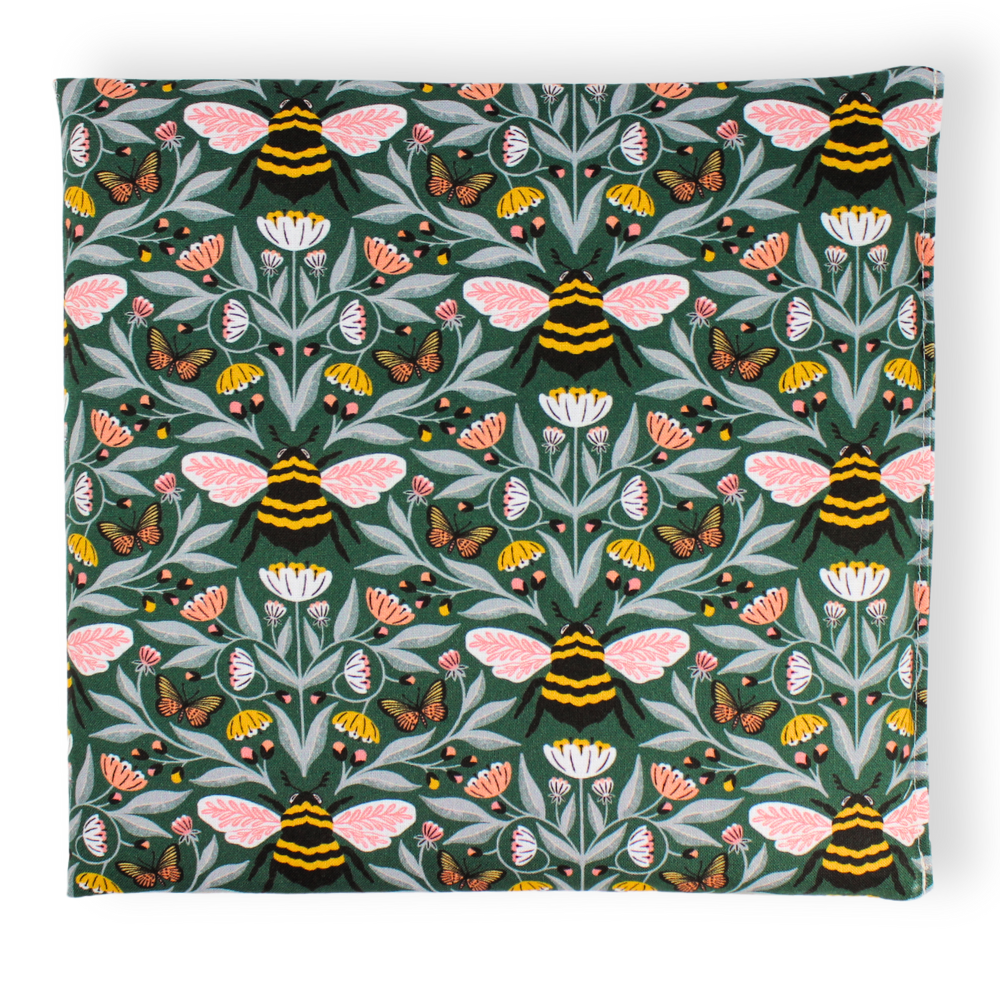 Small aromatherapy hot or cold wrap featuring a detailed botanical and insect pattern on a dark green background, with pink-winged bees, butterflies, flowers, and leaves.