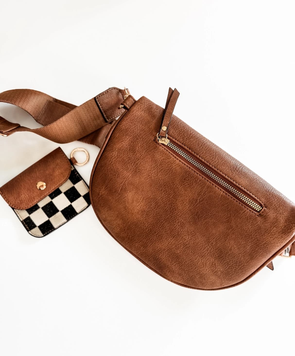 Brown leather crossbody bag with a checkered pouch on a white background