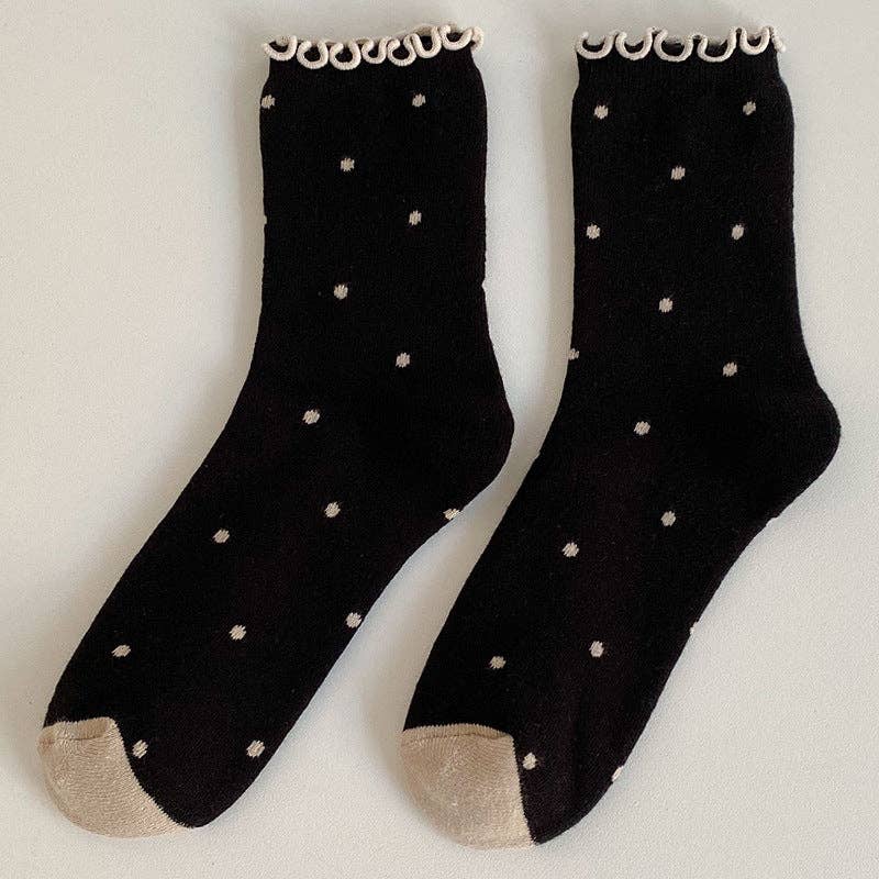 Black socks with white polka dots on a light gray background
