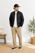 man wearing bomber jacket and hat