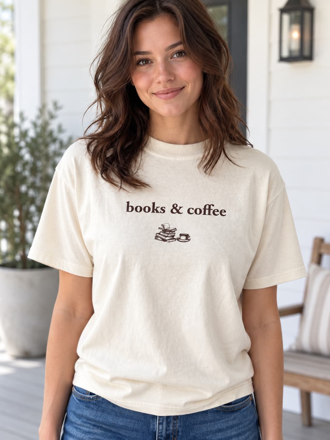 woman wearing cream tee shirt that says "books & coffee" with small stack of books and coffee cup graphic under.