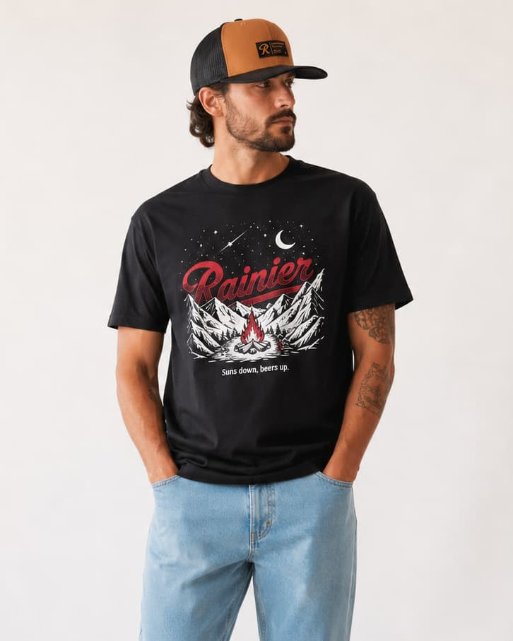 Man in glow in the dark graphic rainier beer tee and snapback hat.