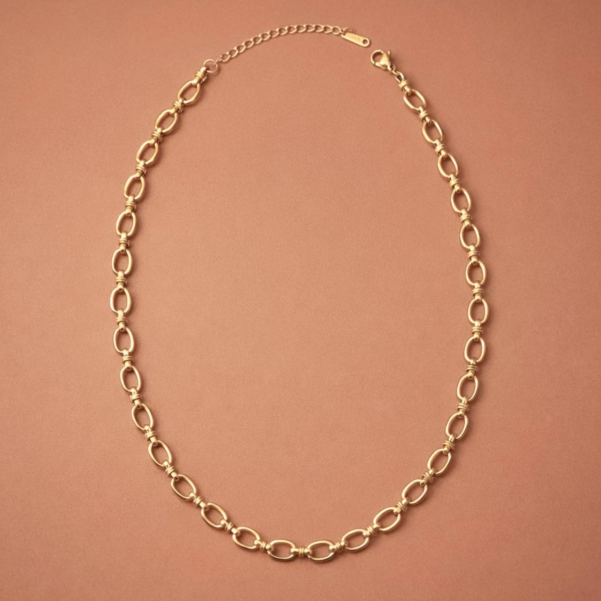 Gold chain necklace on a brown background