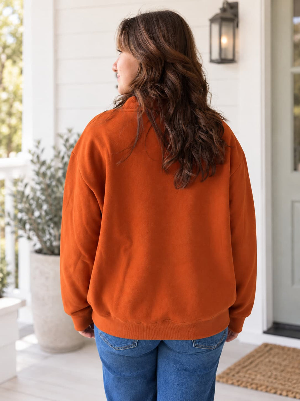 Back of woman wearing a burnt orange sweatshirt.