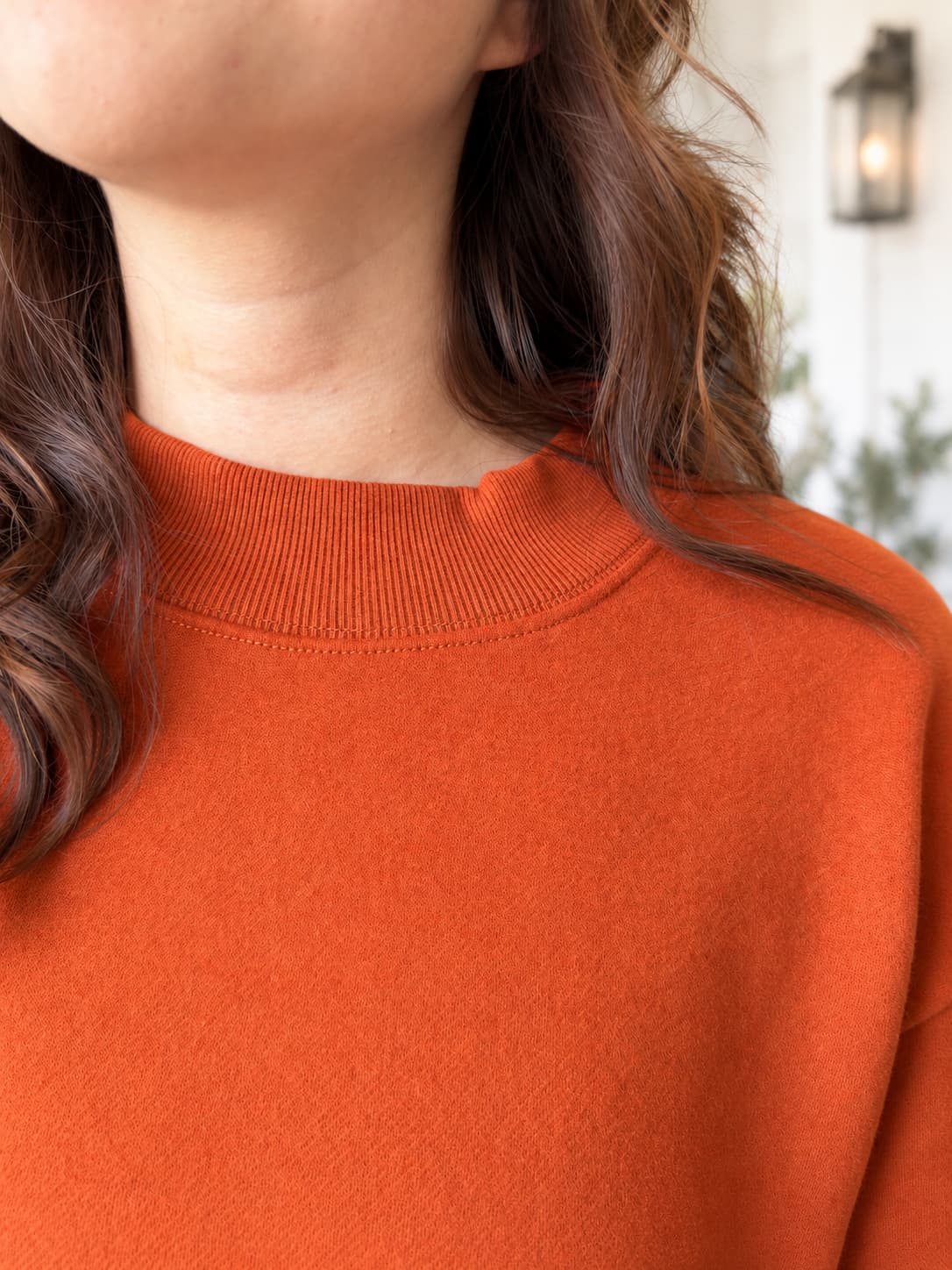 Close up of burnt orange chili oil sweatshirt ribbed mock neckline.