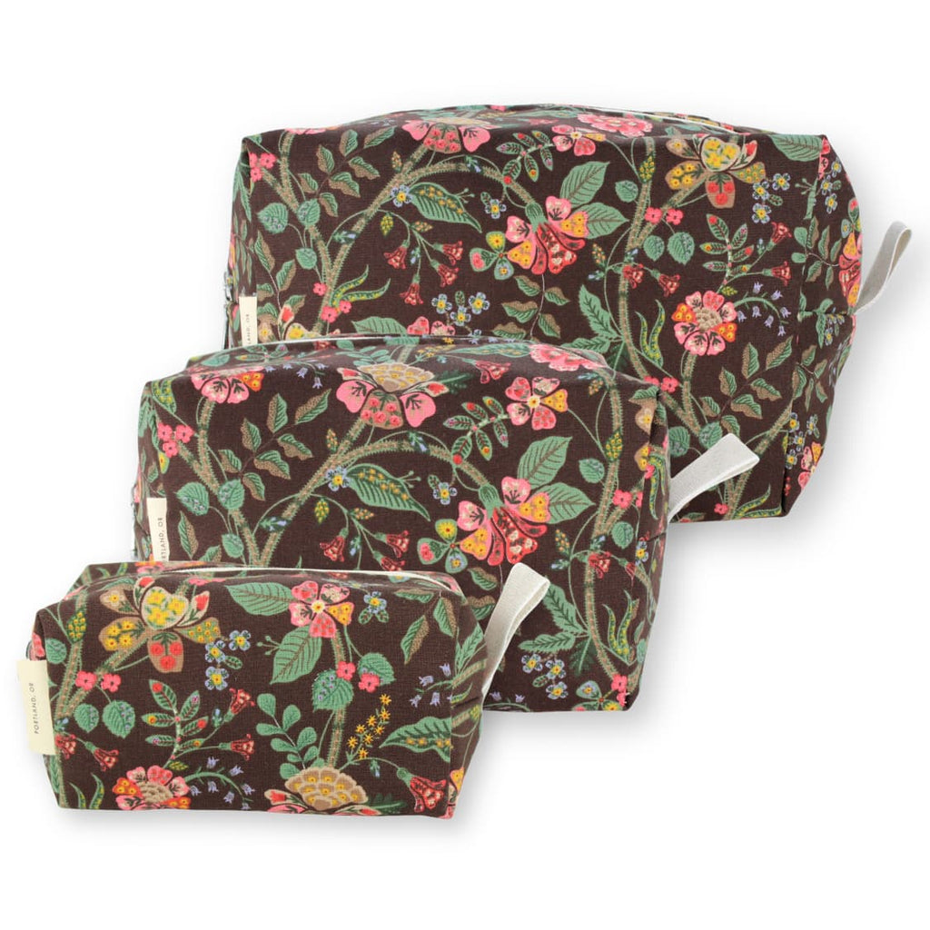 Three nested fabric storage bags with a brown background and a colorful floral print, shown on a white background.