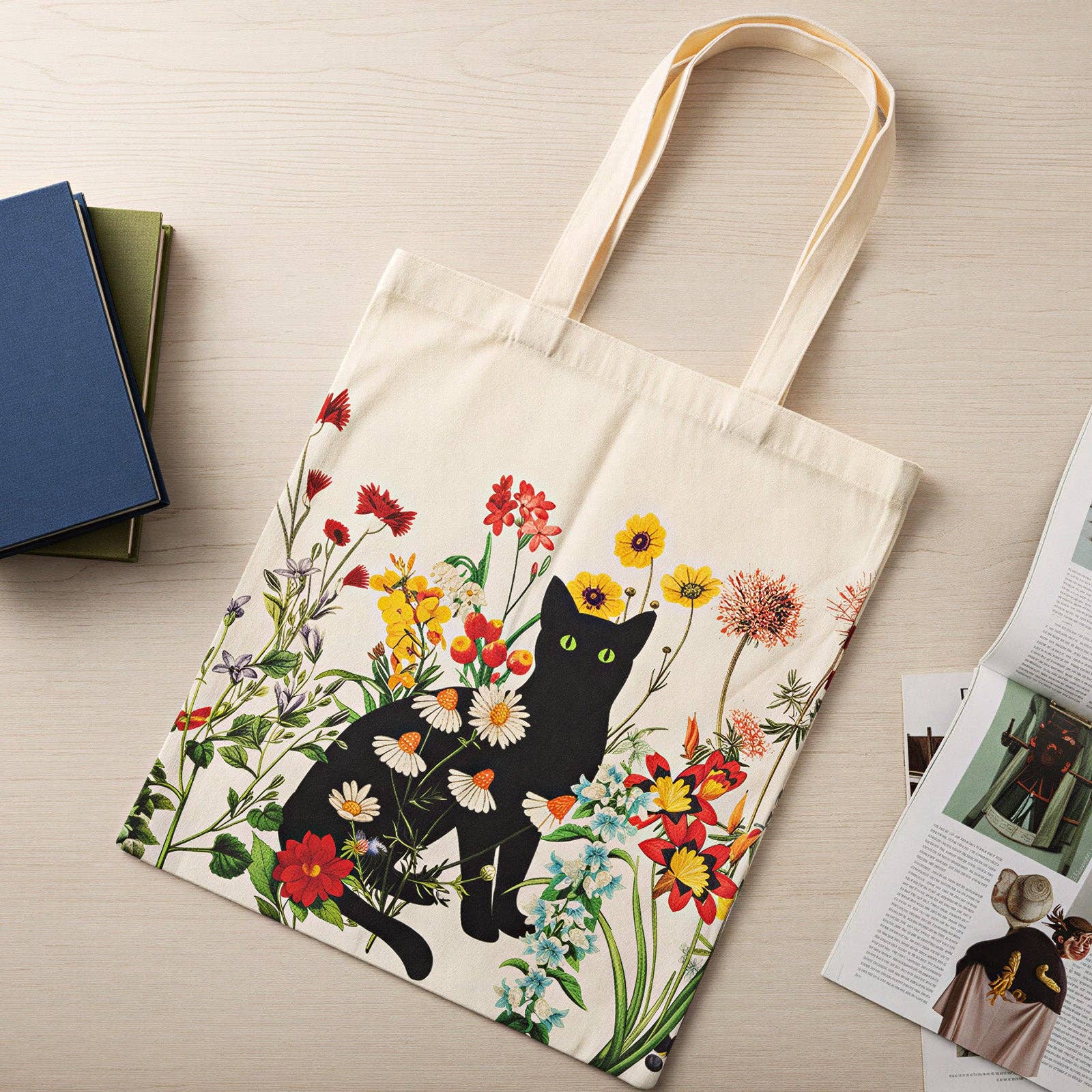 Tote bag with a black cat and floral design on a wooden surface