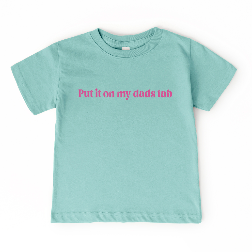 Light blue t-shirt with pink text 'Put it on my dad's tab' on a white background