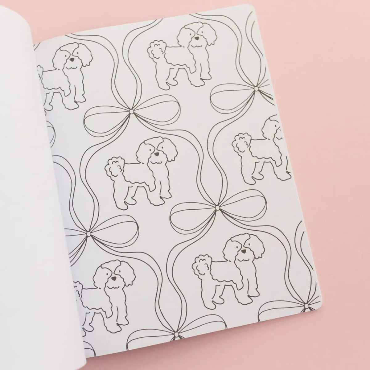 A coloring book page of folded fabric with dog and bow pattern on a pink background