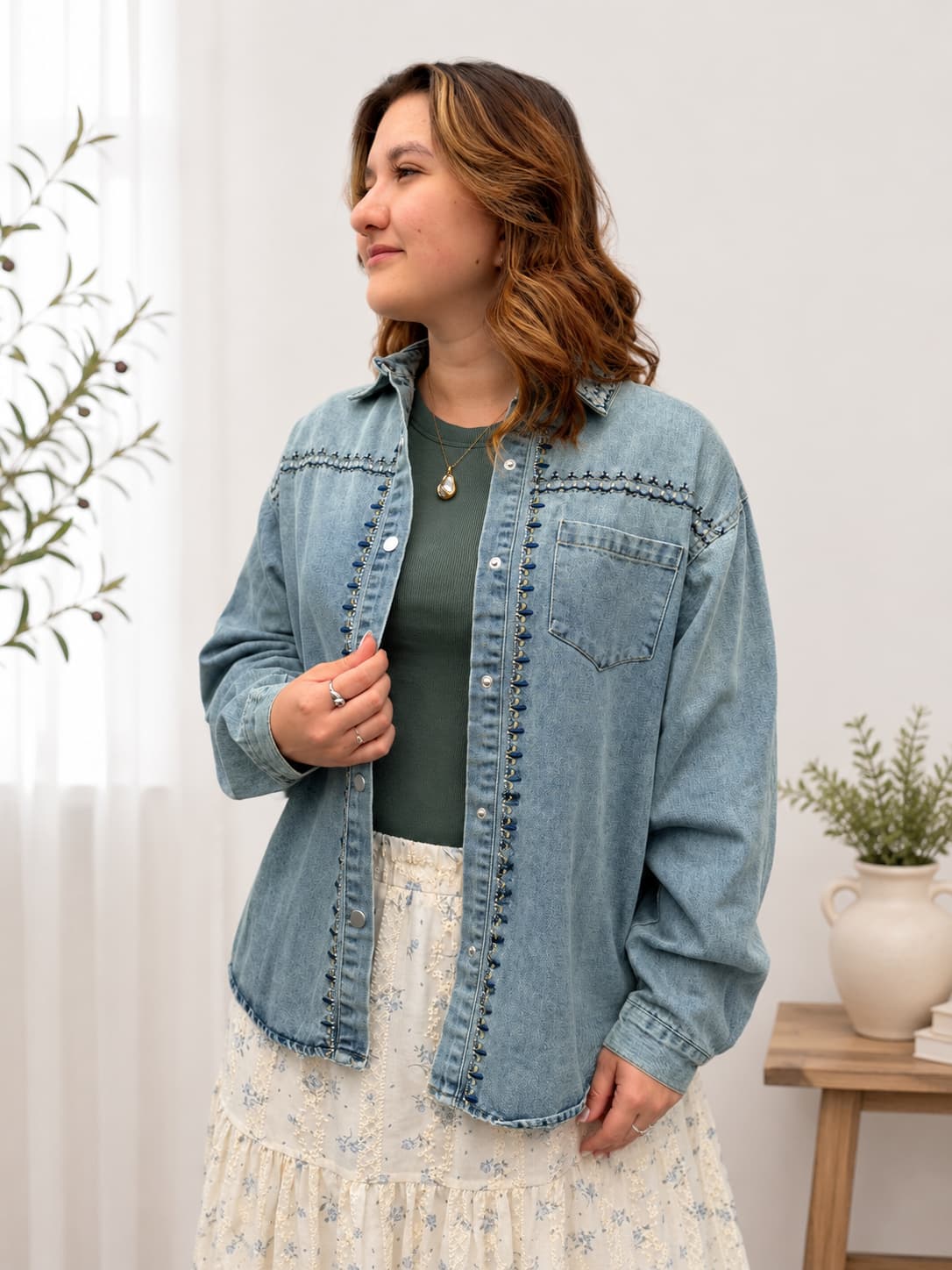 Woman wearing a embroidered denim jacket in a home setting