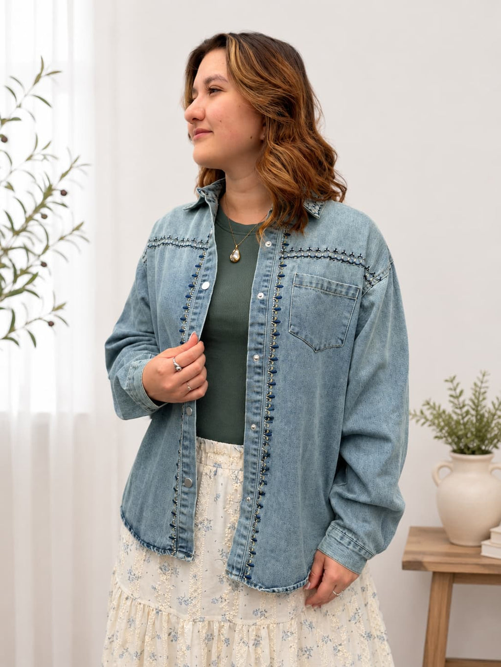 Woman wearing styled tee shirt with denim coat and floral skirt.