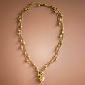 Gold necklace with heart pendant on a brown background