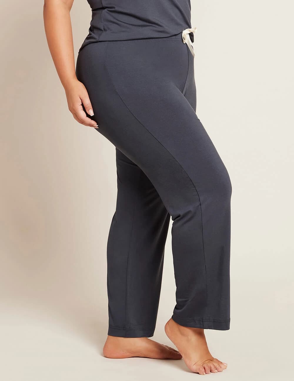 Person wearing dark gray pants on a plain background