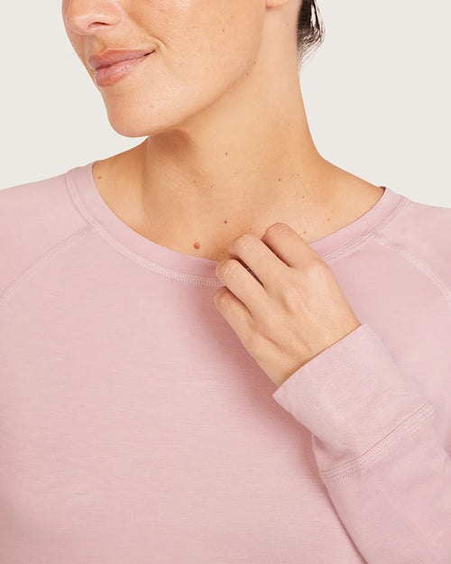 Person wearing a lilac longsleeve with a plain background