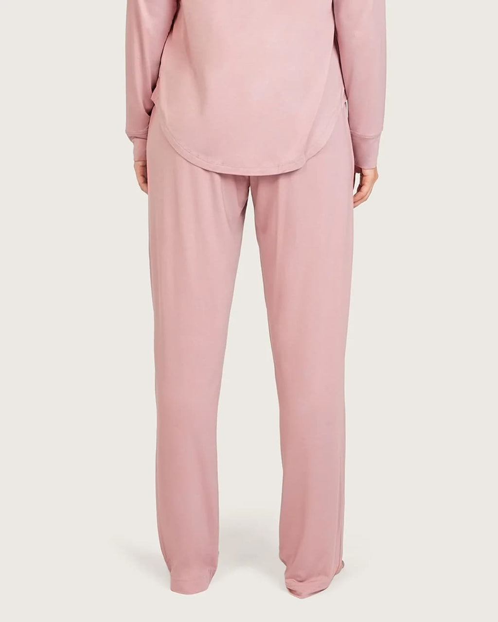 A person wearing a matching dusty lilac lounge set consisting of a long-sleeve top and straight-leg pants, shown from the back against a light gray studio background.