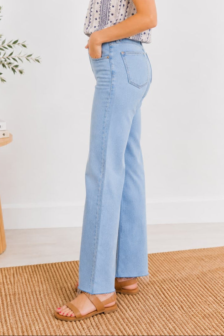 Side detail of woman wearing light blue denim and boho print tank.