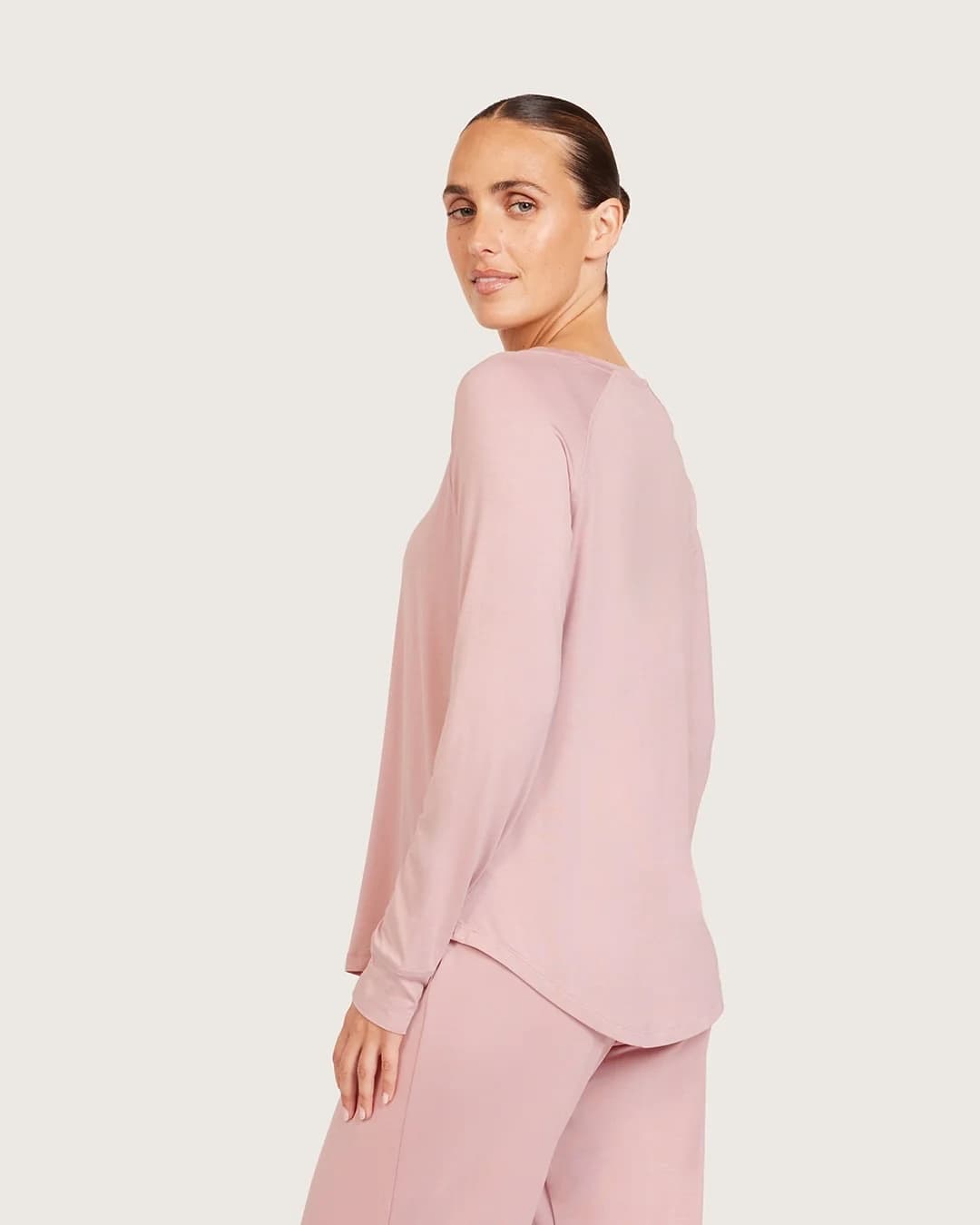 Woman wearing a lilac outfit on a beige background
