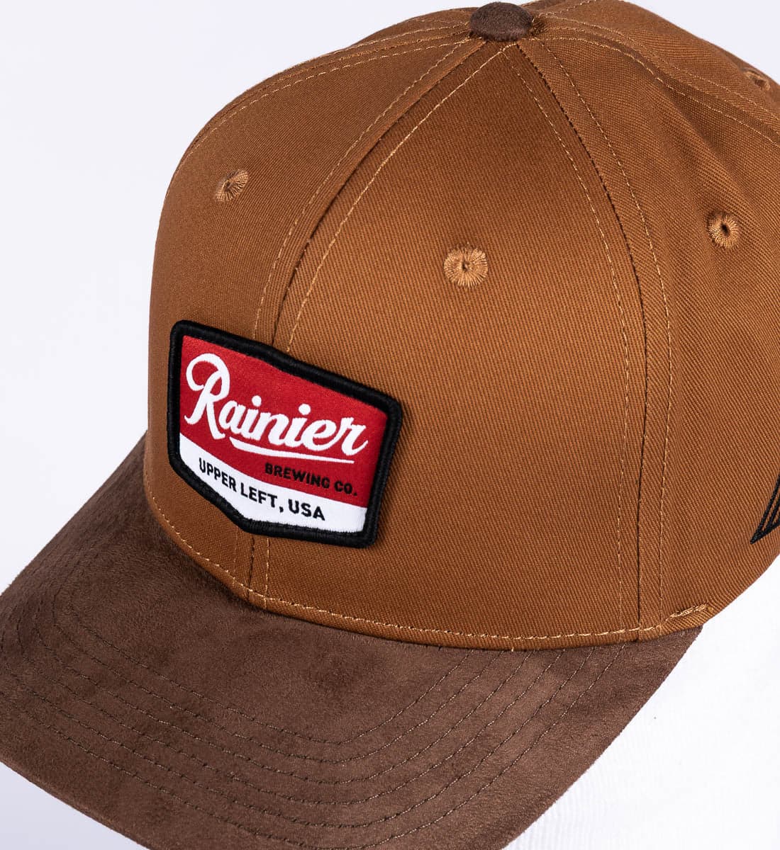 Brown cap with a 'Rainier' patch logo on a white background