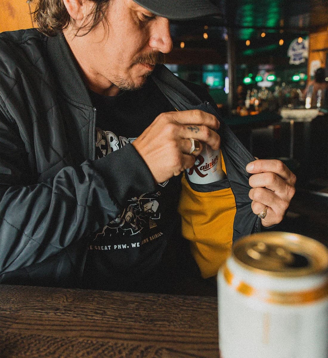 Man wearing quilted bomber with beer pocket on the inside.