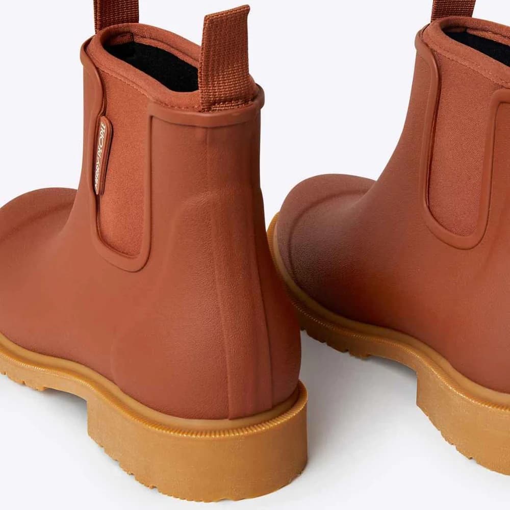 Pair of brown rubber rain boots and neoprene lining with tan soles on a white background
