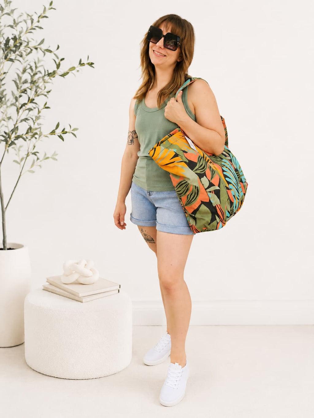 Woman holding a colorful bag in a minimalistic indoor setting