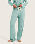 Person wearing a mint green pajama set on a white background