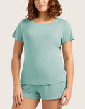 A woman wearing a matching mint green short-sleeve t-shirt and shorts set, shown from the head down against a plain light beige background.