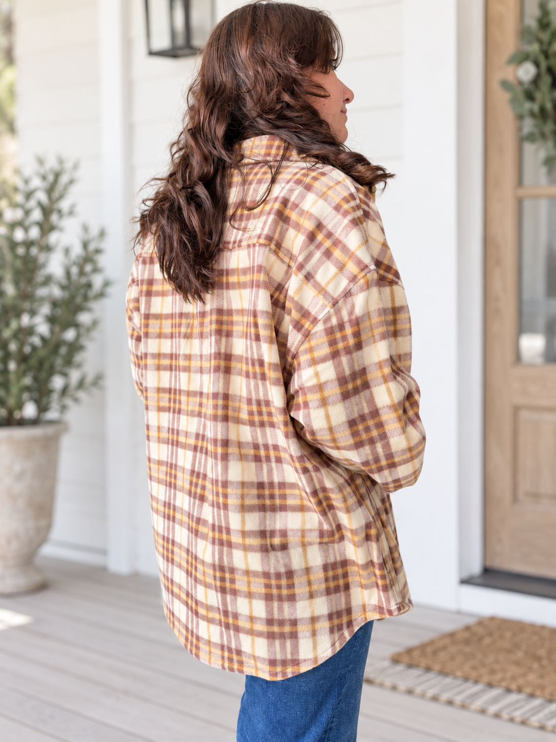 woman wearing fleece plaid jacket from the back side view.